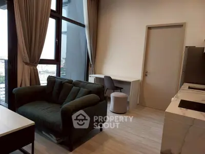 Modern living room with large windows, stylish sofa, and sleek kitchen area in a high-rise apartment.