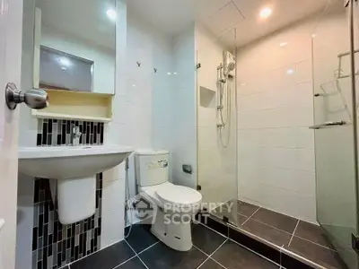 Modern bathroom with sleek design, featuring a glass shower and contemporary fixtures.