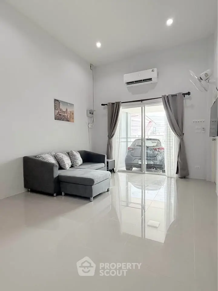 Spacious modern living room with sleek tile flooring and large window view of carport.