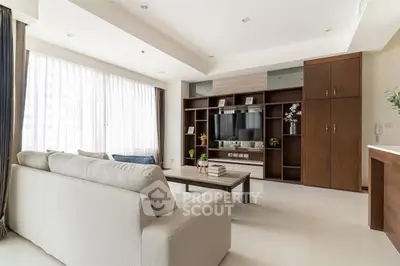 Spacious modern living room with large windows and elegant furniture.