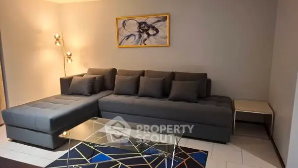 Modern living room with stylish gray sectional sofa and abstract art, perfect for contemporary living.