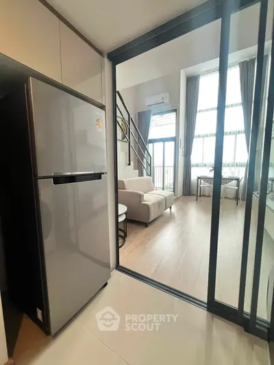 Modern duplex apartment with sleek kitchen and spacious living area, featuring large windows and stylish decor.