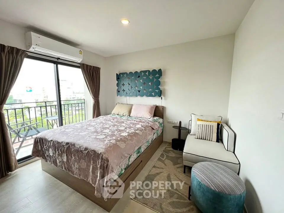 Charming bedroom with balcony access, modern decor, and ample natural light.