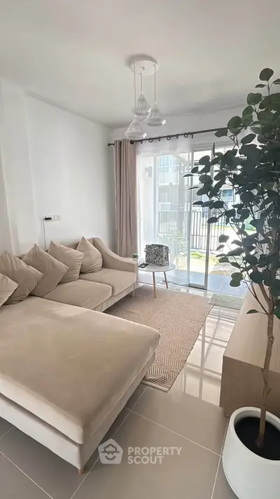 Modern living room with cozy beige sofa and large window view