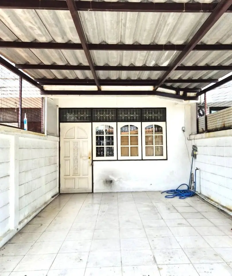 Spacious covered patio with tiled flooring and white walls, perfect for outdoor gatherings.
