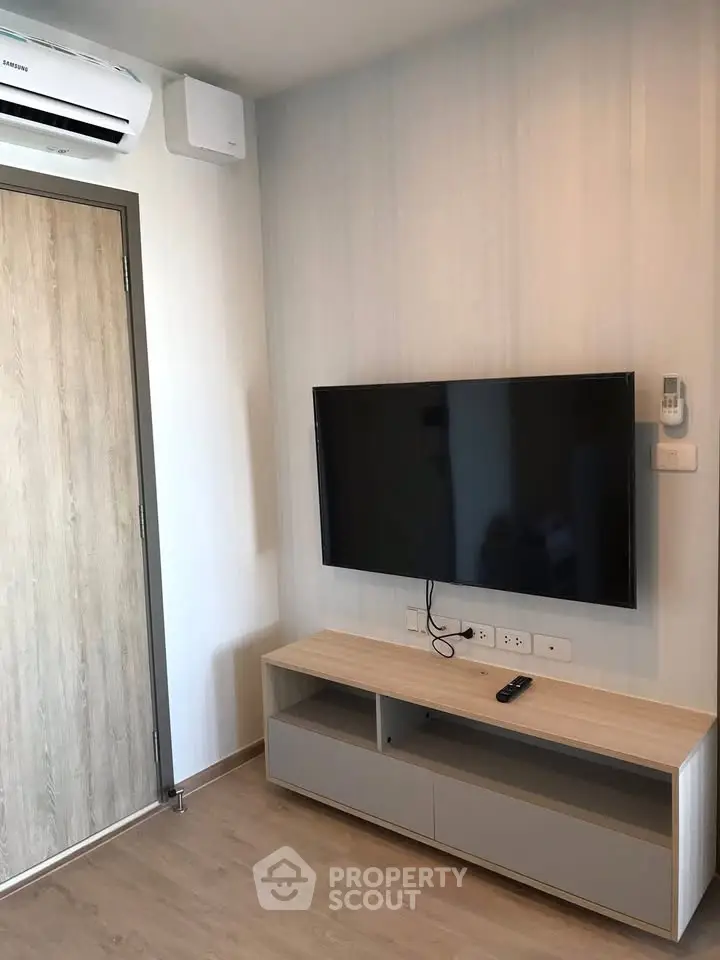 Modern living room with wall-mounted TV and sleek air conditioning unit.