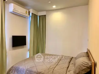 Cozy bedroom with modern air conditioning and wall-mounted TV, perfect for relaxation.