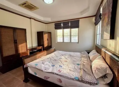 Spacious bedroom with natural light and elegant wooden furniture