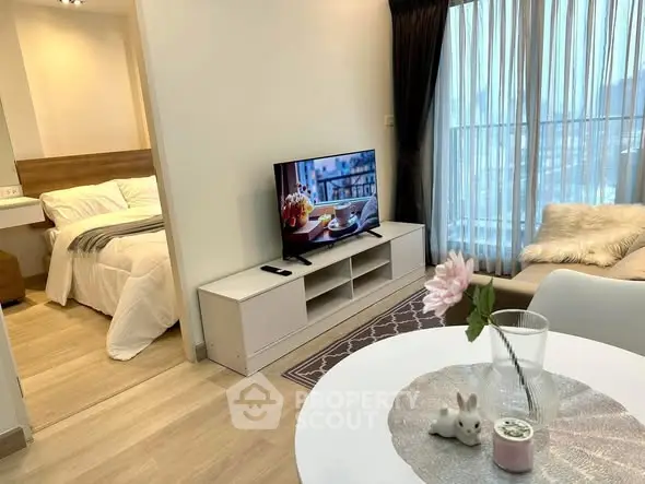 Modern living room with cozy decor and adjacent bedroom in a stylish apartment.