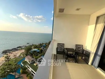Stunning ocean view from a modern balcony with elegant outdoor seating, perfect for relaxation.