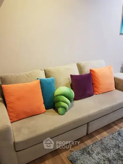 Cozy living room with colorful cushions on a beige sofa, perfect for relaxation.