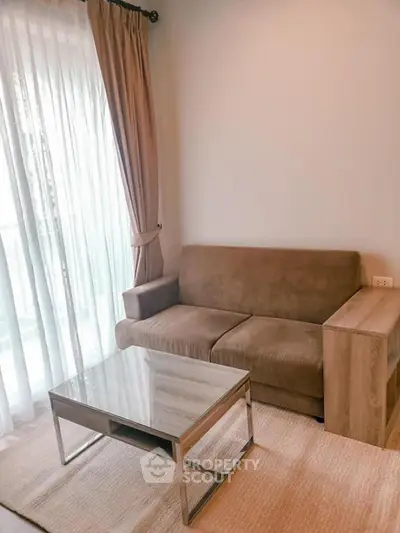Cozy living room with brown sofa and glass coffee table, perfect for relaxation.