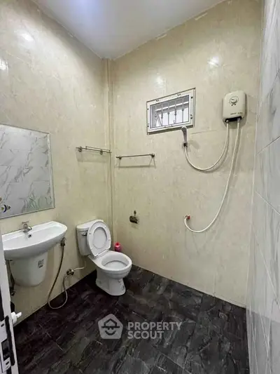 Modern bathroom with sleek fixtures and tiled walls, featuring a wall-mounted water heater.