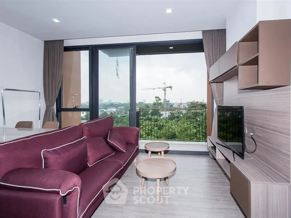 Modern living room with large windows and scenic view, featuring stylish furniture and contemporary design.