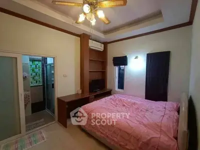 Cozy bedroom with ensuite bathroom, featuring a ceiling fan and built-in storage, perfect for comfort and convenience.