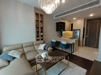 Modern living room with open kitchen, stylish decor, and cozy seating area.