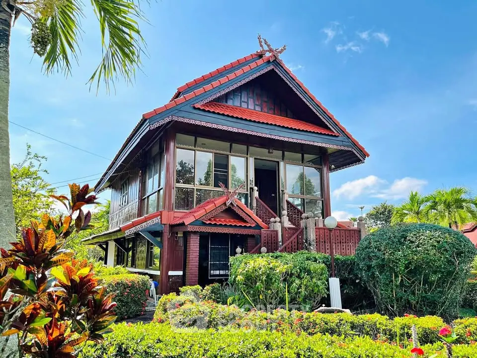Charming traditional wooden house with lush garden and vibrant greenery, perfect for serene living.