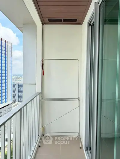 Modern balcony with city view and glass doors in high-rise apartment