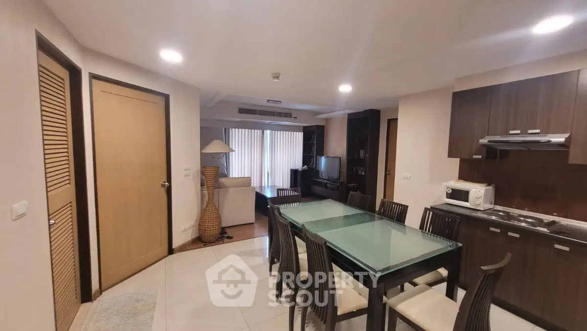 Spacious open-plan living and dining area with modern kitchen in stylish apartment.