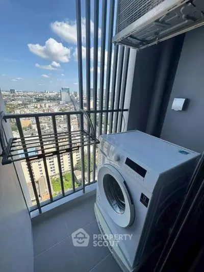 High-rise balcony with washing machine and stunning city view, perfect for urban living.