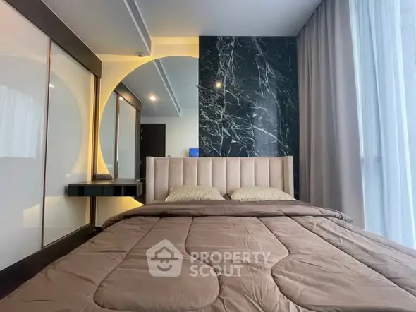 Modern bedroom with stylish decor and large window for natural light.