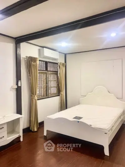 Charming bedroom with elegant white furniture and warm wooden flooring