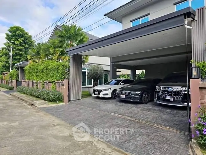 Modern house with spacious driveway and luxury cars parked, showcasing contemporary architecture.