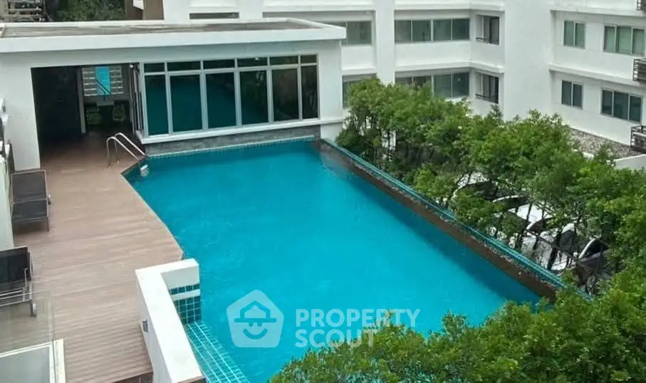 Luxurious apartment complex with a stunning rooftop pool and lush greenery.