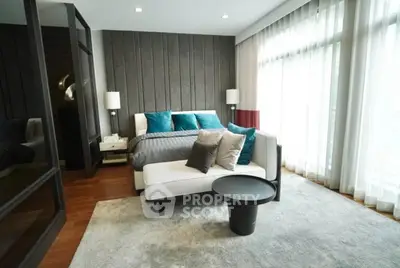 Luxurious bedroom with modern decor and large windows offering natural light