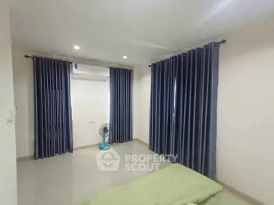 Spacious bedroom with modern curtains and air conditioning, perfect for comfort and relaxation.