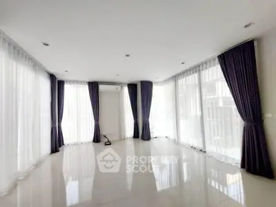 Spacious living room with large windows and elegant curtains