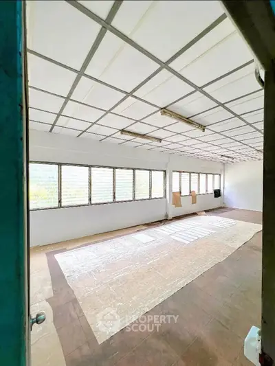 Spacious unfurnished room with large windows and natural light