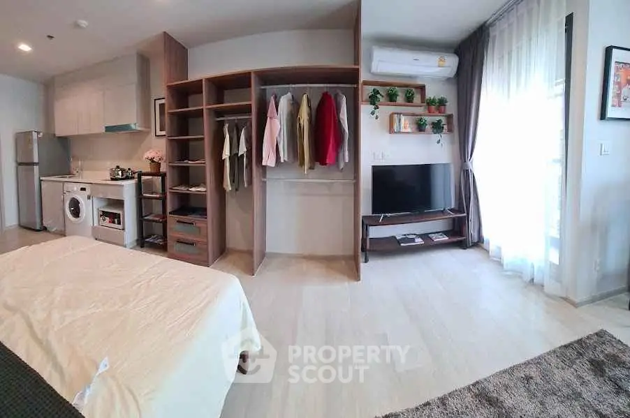 Modern studio apartment with open layout, featuring a cozy living area, kitchen, and stylish storage solutions.