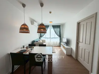 Modern living room with dining area, stylish lighting, and natural light from large windows.