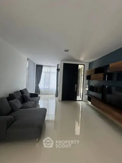 Spacious modern living room with sleek furniture and large windows for natural light.
