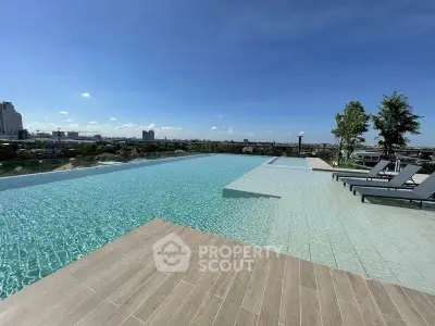 Luxurious rooftop infinity pool with stunning city skyline views and sun loungers.
