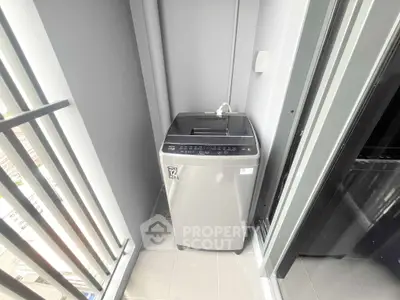 Compact balcony with modern washing machine in sleek urban apartment.