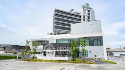 Modern commercial building with spacious parking area and contemporary design.