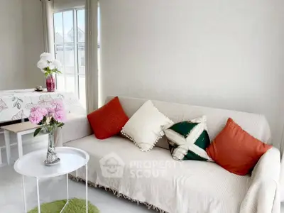 Bright living room with cozy sofa and vibrant cushions, perfect for relaxation.