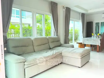 Spacious living room with large windows and modern furniture in a bright home.