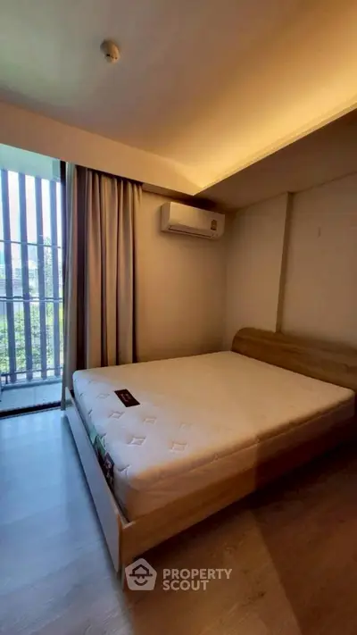 Cozy bedroom with natural light and modern air conditioning unit, perfect for relaxation.