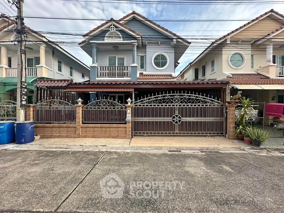 Charming suburban house with decorative iron gate and balcony