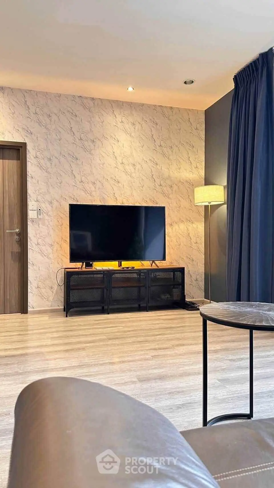 Modern living room with stylish decor and large flat-screen TV, perfect for relaxation and entertainment.