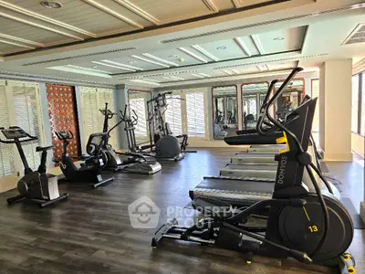 Spacious modern gym with state-of-the-art fitness equipment and elegant interior design.