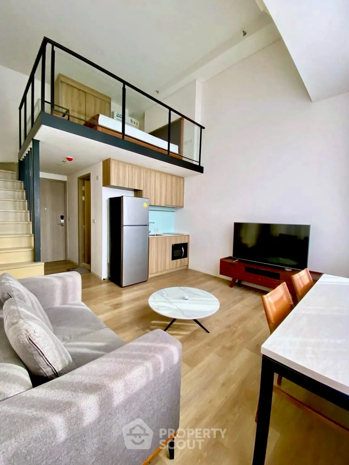 Modern loft apartment with open layout, stylish furniture, and mezzanine level.