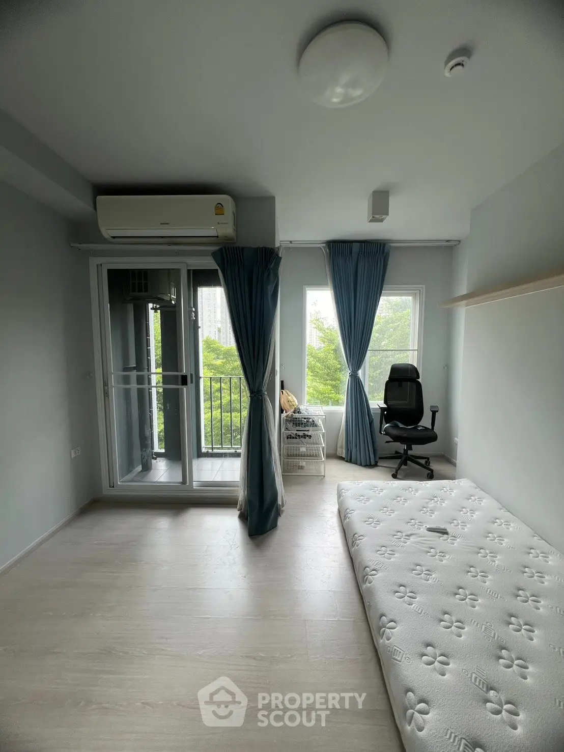Spacious bedroom with balcony access and modern furnishings in a serene setting.