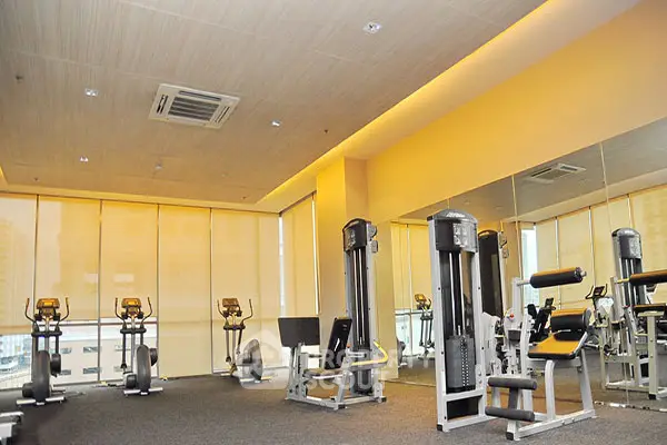 Modern gym with state-of-the-art fitness equipment and mirrored walls in a high-rise building.