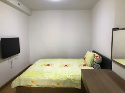 Cozy bedroom with modern decor and wall-mounted TV in a stylish apartment.