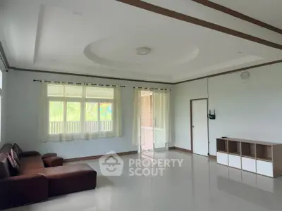 Spacious living room with modern design and large windows offering natural light.