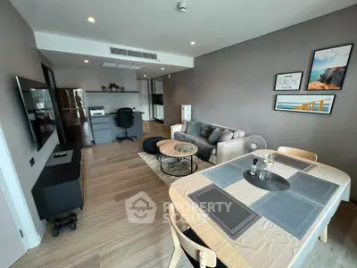 Modern living room with stylish decor and open layout, featuring a cozy dining area and sleek furniture.